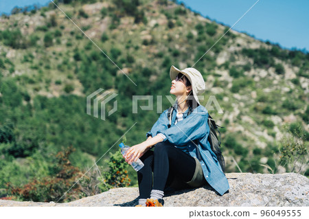 Woman taking a break from climbing 96049555