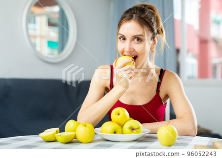Portrait of a happy woman with apples at the table in room at home. Diet and weight loss concept 96052243
