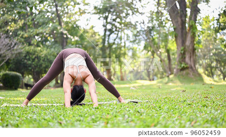 Healthy Asian woman in sportswear practicing yoga, doing Wide-legged standing forward bend pose 96052459