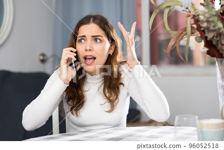 Angry woman arguing while having telephone conversation Angry woman arguing while having telephone conversation 96052518