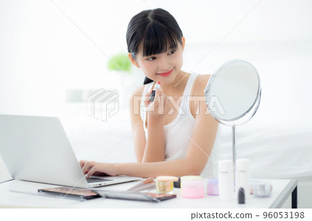 Beauty of young asian woman with learning makeup with lipstick on mouth watching laptop. Beauty of young asian woman with learning makeup with lipstick on mouth watching laptop. 96053198