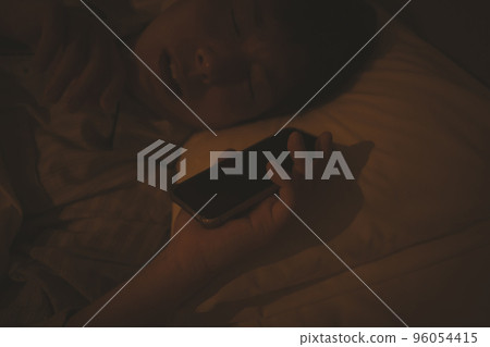 A man in his 40s sleeping with a bedroom and a smartphone A man in his 40s sleeping with a bedroom and a smartphone 96054415