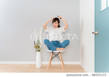 Japanese woman applying hair care products and styling products to her hair 96055172