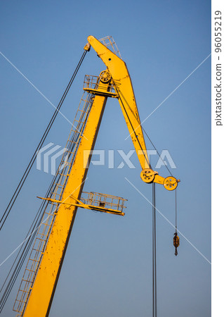 Upper part of yellow port crane is under blue sky Upper part of yellow port crane is under blue sky 96055219