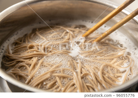Soba noodles being boiled in a pot 96055776