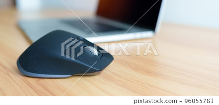 Ergonomic vertical mouse with laptop computer on adjustable desk at workplace, prevention wrist pain. De Quervain s tenosynovitis, Intersection Symptom, Carpal Tunnel or Office syndrome concept 96055781