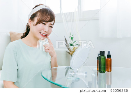 A woman suffering from back teeth, unfamiliarity, and stomatitis while looking at the mirror at home 96056286