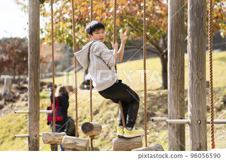 Boy having fun and cheerfully playing in the autumn park 96056590