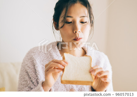 A woman eating bread 96057013