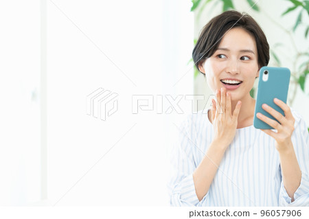 Woman receiving online dental treatment on smartphone Woman receiving online dental treatment on smartphone 96057906