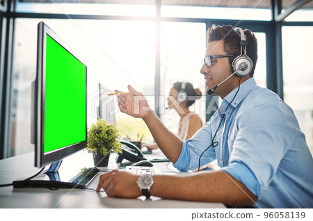The best team to handle your queries. Cropped shot of a handsome young man working in a call center with a female colleague in the background. 96058139