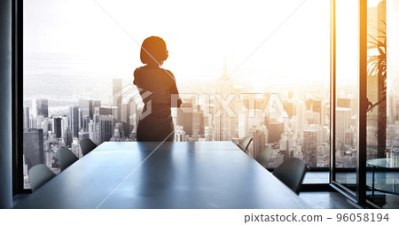 Soon Ill be running this city. Rearview shot of a young businesswoman looking out from a large window in the office. Soon Ill be running this city. Rearview shot of a young businesswoman looking out from a large window in the office. 96058194
