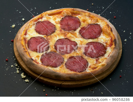 Spicy pizza with salami . Italian traditional food. Popular street food. Spicy pizza with salami . Italian traditional food. Popular street food. 96058286