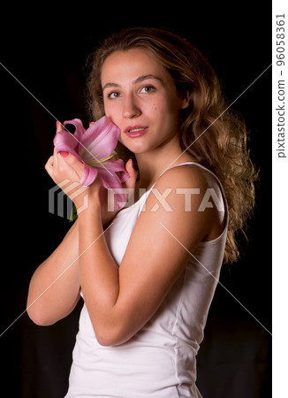 Beauty face of the young beautiful woman with flower. Female touching skin. Beauty face of the young beautiful woman with flower. Female touching skin. 96058361