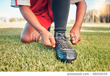 Sports, football field and child tie shoes for match workout, challenge contest or practice exercise on grass pitch. Athlete fitness health, training black kid or youth soccer player ready for game Sports, football field and child tie shoes for match workout, challenge contest or practice exercise on grass pitch. Athlete fitness health, training black kid or youth soccer player ready for game 96058439
