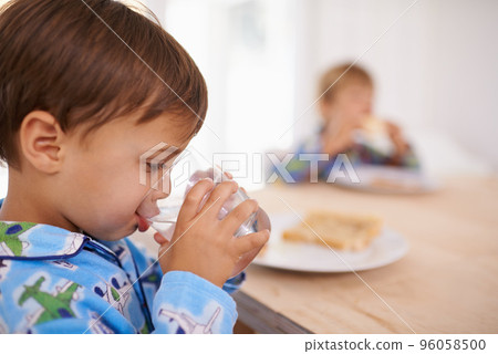 Washing it down. A cute little boy having a drink of water with breakfast. Washing it down. A cute little boy having a drink of water with breakfast. 96058500