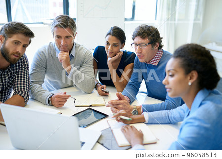 Faster, more efficient meetings with the help of technology. A group of business colleagues discussing work on a laptop during a boardroom meeting. 96058513