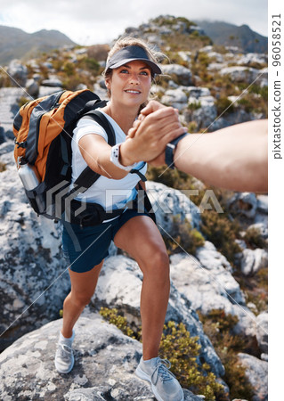 Woman get help hand on mountain hiking with partner, friends or coach for fitness, health and adventure. Girl hiker, helping hand and support on nature rocks outdoor for wellness, fun and exercise 96058521