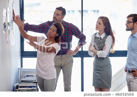 Getting their priorities in order. Shot of a group of colleagues having a brainstorming session at work. 96058569