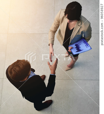 Welcome to the company. Shot of two businesspeople shaking hands in an office. Welcome to the company. Shot of two businesspeople shaking hands in an office. 96058927