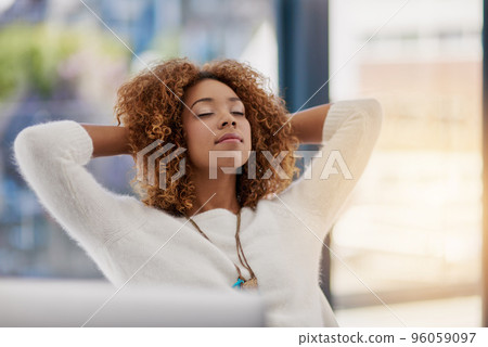Contemplating the road to success. Shot of a young entrepreneur leaning back in her chair with her hands behind her head. Contemplating the road to success. Shot of a young entrepreneur leaning back in her chair with her hands behind her head. 96059097