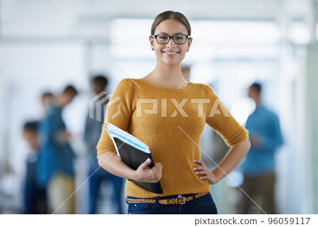 Im taking my business to the top. Portrait of a young office worker standing in an office with colleagues in the background. 96059117