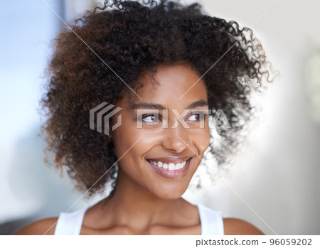Happy thoughts. Shot of an attractive young woman looking thoughtful in her home. Happy thoughts. Shot of an attractive young woman looking thoughtful in her home. 96059202