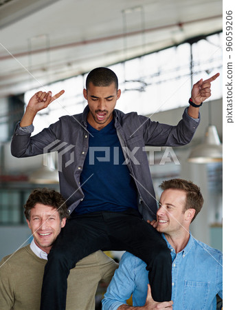 Celebrating his success. Two coworkers lifting up a third on their shoulders. 96059206