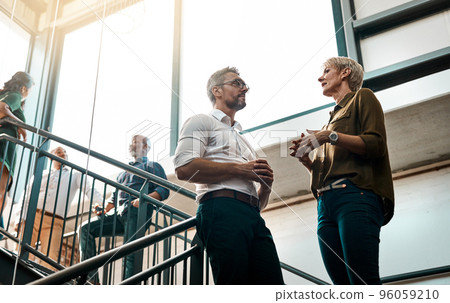 Great ideas come from casual conversations. Shot of two businesspeople talking to each other while standing on a stairwell. 96059210