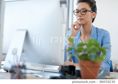 Working towards financial stability. Professional young woman thinking while looking at the screen of her pc in her office. Working towards financial stability. Professional young woman thinking while looking at the screen of her pc in her office. 96059230