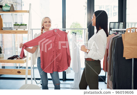 Can I have this in my size. Shot of a sales assistant helping a young woman in a clothing boutique. 96059606