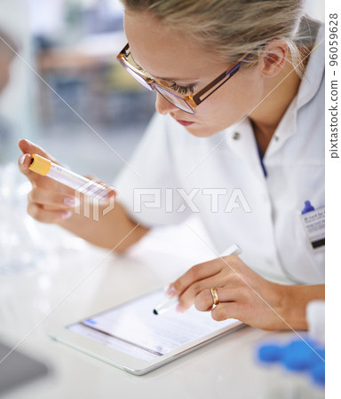 Research and development. A young scientist recording her findings on a tablet. Research and development. A young scientist recording her findings on a tablet. 96059628