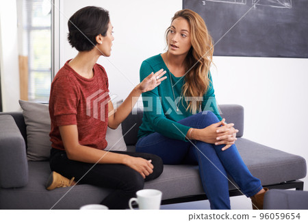 Theyre working together on an exciting project. Shot of two female professionals having a discussion in an informal office setting. 96059654