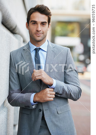 Working in the city. A handsome young businessman looking at the camera. Working in the city. A handsome young businessman looking at the camera. 96059735