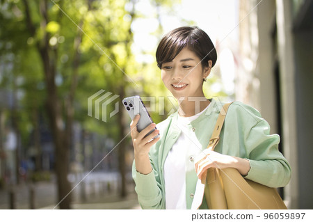 Young woman holding a smartphone Young woman holding a smartphone 96059897