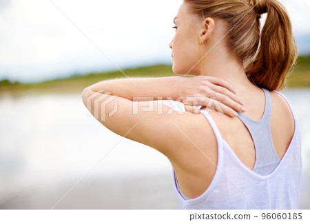 This is so painful. Rearview shot of a young woman touching her shoulder. 96060185