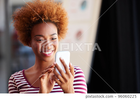 Connected to modern life. A young businesswoman using her phone in the office. 96060225