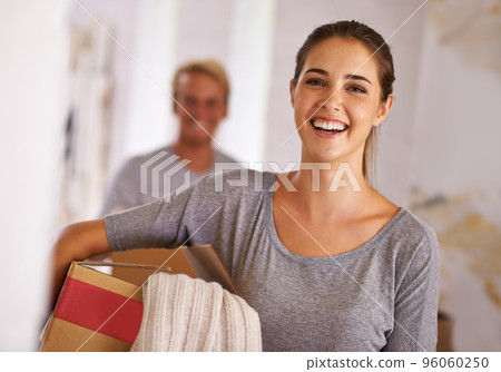 Moving onwards and upwards. Portrait of a young woman holding a box on moving day. 96060250