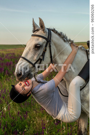 Beautiful young girl smile at her horse dressing uniform competition: outdoors portrait on sunset Beautiful young girl smile at her horse dressing uniform competition: outdoors portrait on sunset 96060266