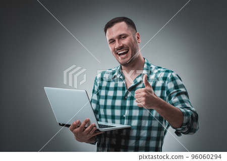 Portrait of young handsome man using laptop, wearing plaid shirt 96060294