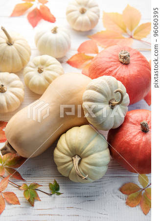 Autumn leaves and pumpkins over old wooden background Autumn leaves and pumpkins over old wooden background 96060395