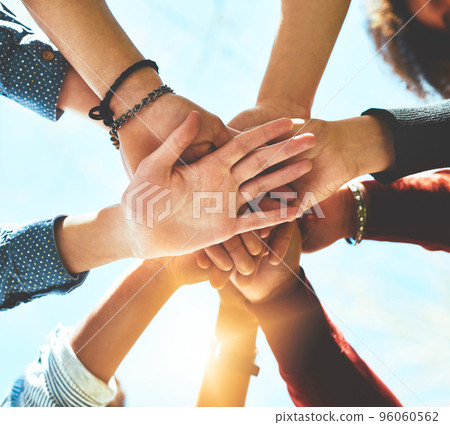 In it to win it. High angle shot of an unrecognizable group of college friends standing outside with their hands in a huddle. 96060562