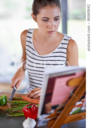 Healthy is on tonights menu. Shot of a young girl cooking in a kitchen. 96060642