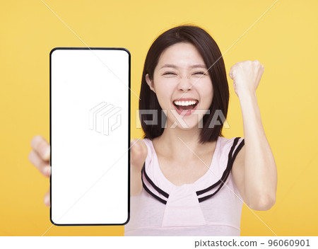 Happy Young woman showing blank screen Smartphone  96060901