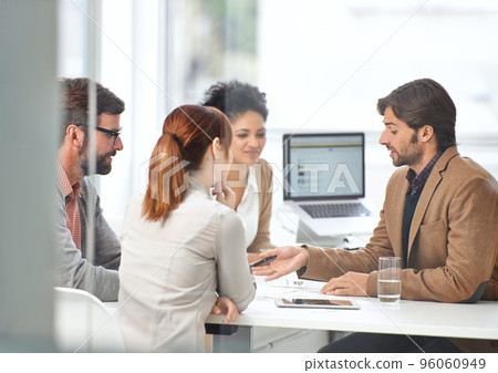 Teamwork gets business done. A group of businesspeople going over some plans together. Teamwork gets business done. A group of businesspeople going over some plans together. 96060949