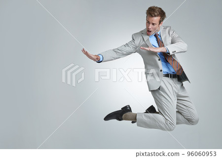 Flying high. A young businessman wildly celebrating his success. 96060953