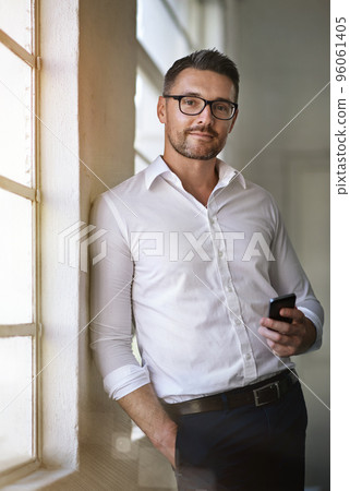 Im always available to my clients. Cropped portrait of a businessman sending a text in his office. Im always available to my clients. Cropped portrait of a businessman sending a text in his office. 96061405