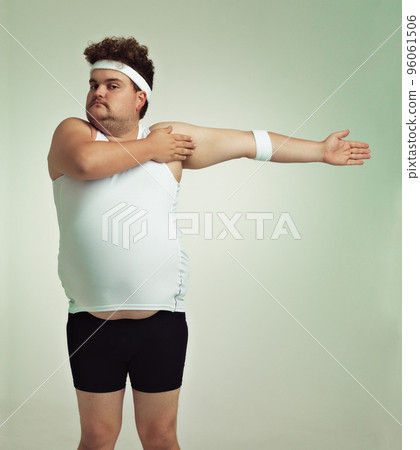Stretching is important. Overweight man doing arm stretches. 96061506