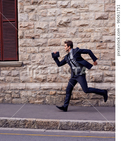 Im late. Shot of a young businessman running down a street. 96061751