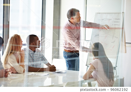 Motivating his staff through effective training. Shot of a group of business colleagues in a boardroom meeting. Motivating his staff through effective training. Shot of a group of business colleagues in a boardroom meeting. 96062192